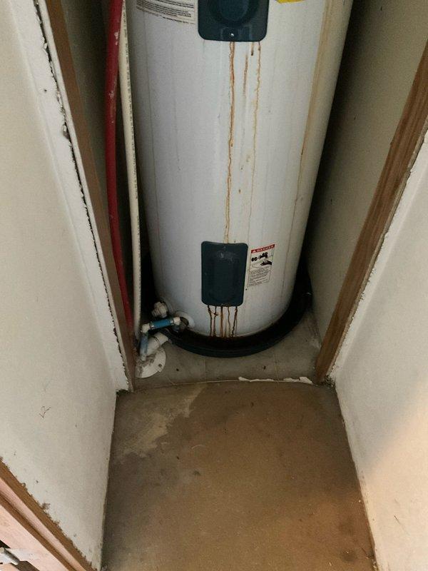 Conducted comprehensive assessment of existing residential water heater installation showing visible signs of deterioration and corrosion staining on exterior tank surface. Documented current water heater condition including rust streaking from top connections, existing copper supply piping configuration, pressure relief valve assembly, and flexible connector installations. Evaluated utility closet space constraints and clearance requirements for potential replacement unit. Photographed electrical panel configuration and circuit availability to support water heater replacement specifications. Provided detailed estimate for 8-10 year warranty water heater replacement including removal of existing unit, installation of new water heater with proper venting, code-compliant connections, and necessary permit coordination.