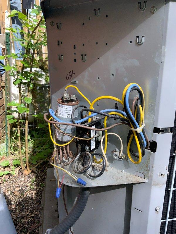 Responded to no-cool call on 20-year-old central air conditioning system that struggled to start this spring and was running but not producing cooling. Upon arrival, performed diagnostic inspection of outdoor condensing unit, examining electrical components including capacitor, wiring harness, and contactor assembly. Unit identified as a 2½-ton R410A system (Model 244BB345H0310) with TXV metering device, factory charged with 7.00 lbs refrigerant, rated at 208-230V with 17A minimum circuit ampacity. Documented system condition through photographs showing weathered electrical panel with exposed capacitor and wire connections, as well as unit nameplate data. Given the advanced age of the equipment at 20 years old—well beyond typical 10-15 year service life expectancy—and reported performance issues, provided comprehensive system evaluation and discussed repair versus replacement options with customer to help determine most cost-effective solution for restoring cooling comfort to the home.
