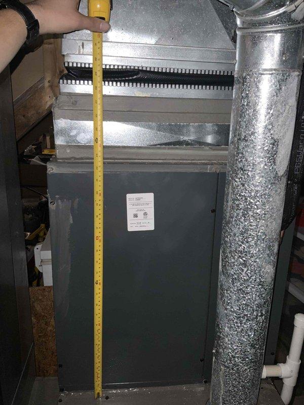 Conducted on-site warranty assessment to determine if 30-inch coil would fit as replacement for existing coil in air handler unit. Measured vertical height and horizontal width of current unit and access opening using tape measure, documenting dimensions with photographs for equipment compatibility verification. Customer was unavailable during visit as anticipated, but visual inspection and measurements were successfully completed to provide specifications needed for coil replacement determination.