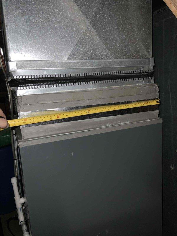 Conducted on-site warranty assessment to determine if 30-inch coil would fit as replacement for existing coil in air handler unit. Measured vertical height and horizontal width of current unit and access opening using tape measure, documenting dimensions with photographs for equipment compatibility verification. Customer was unavailable during visit as anticipated, but visual inspection and measurements were successfully completed to provide specifications needed for coil replacement determination.