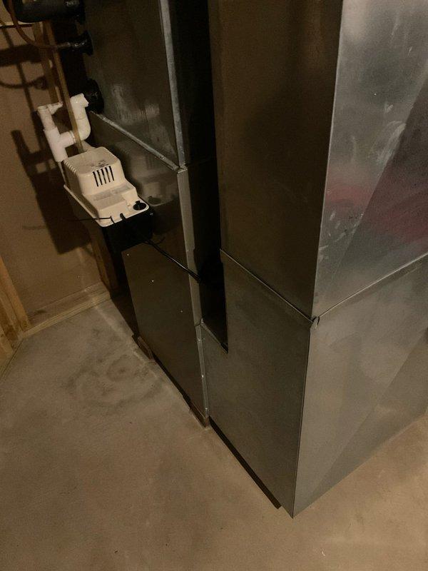 Conducted on-site evaluation of existing 15-year-old central heating and air conditioning system in owner-occupied single family residence to provide replacement estimate. Inspected current furnace and air handler unit located in basement utility area, along with associated condensate pump and drainage system. Assessed installation requirements and existing infrastructure to prepare comprehensive quote for new HVAC system replacement including both heating and cooling equipment.