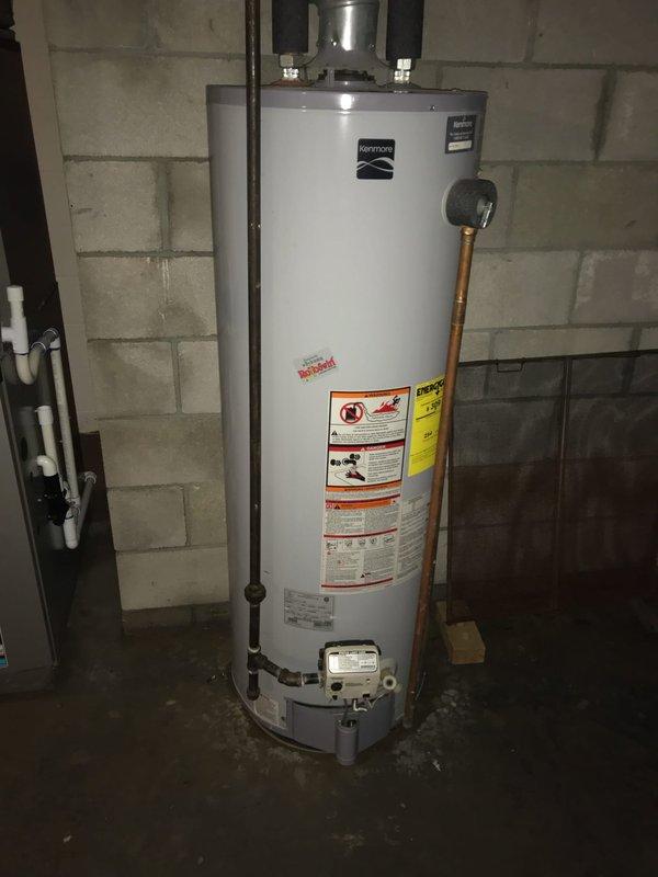 Responded to service call for non-operational water heater. Upon arrival, diagnosed Kenmore tanked water heater failure. Removed existing failed unit and installed new replacement water heater with proper venting and plumbing connections. Connected gas supply line, installed temperature and pressure relief valve with discharge piping, and verified all copper and black pipe connections were secure and code-compliant. Tested unit operation, confirmed proper ignition sequence, and verified hot water delivery throughout system. Left installation clean and fully operational.