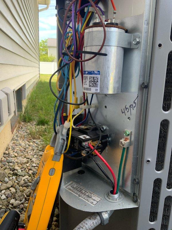Responded to cooling deficiency complaint on residential AC system. Upon inspection, accessed outdoor condensing unit and electrical disconnect to evaluate system components. Examined capacitor, contactor assembly, and electrical connections. Documented condition of electrical wiring, terminal blocks, and internal components showing signs of weathering and debris accumulation. Verified proper electrical connections and component mounting. System evaluated as part of club maintenance agreement visit.