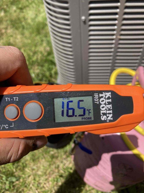 Completed preventive maintenance agreement visit on residential air conditioning system. Performed comprehensive inspection of outdoor condensing unit, including visual assessment of cabinet condition, fan assembly, and condenser coil cleanliness. Recorded operational temperature readings using calibrated digital thermometer, with discharge air temperature measuring 116.5°F, indicating system is operating within normal parameters. Unit exterior shows typical weathering consistent with outdoor exposure but remains structurally sound with adequate airflow through louvered panels and top-mounted fan grille.