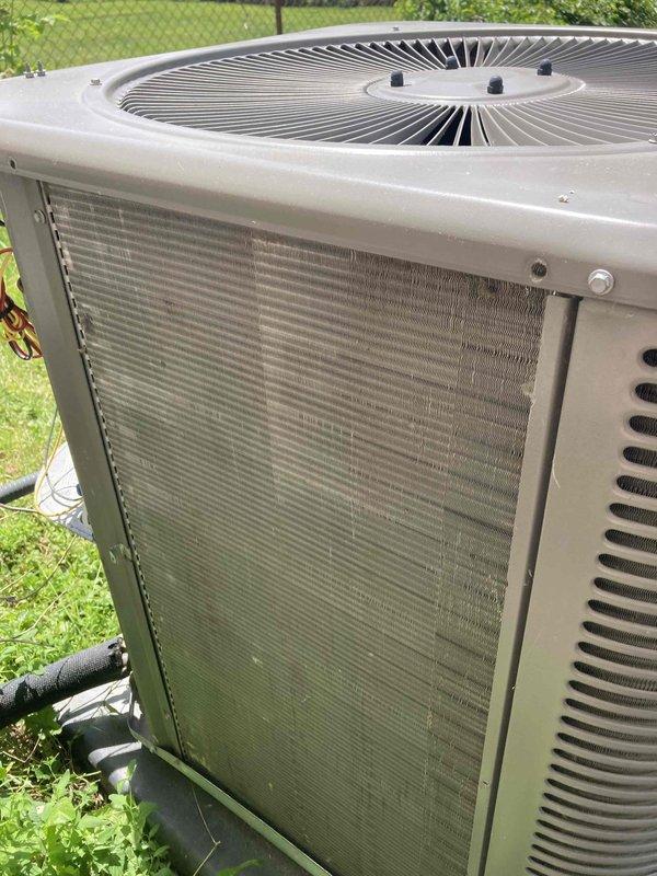 Completed preventive maintenance agreement visit on residential air conditioning system. Performed comprehensive inspection of outdoor condensing unit, including visual assessment of cabinet condition, fan assembly, and condenser coil cleanliness. Recorded operational temperature readings using calibrated digital thermometer, with discharge air temperature measuring 116.5°F, indicating system is operating within normal parameters. Unit exterior shows typical weathering consistent with outdoor exposure but remains structurally sound with adequate airflow through louvered panels and top-mounted fan grille.