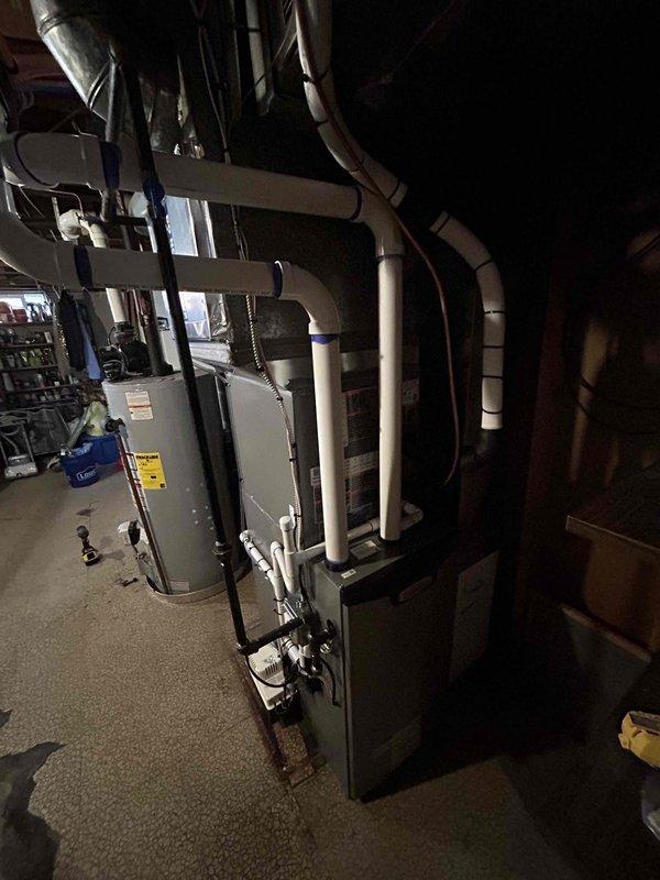 Completed full HVAC system installation in basement mechanical room, including 70,000 BTU gas furnace, 2-ton air conditioning unit with rear discharge configuration, and whole-home humidifier. Installed all mechanical components, electrical connections, and ductwork transitions. Routed PVC condensate drainage lines with proper support strapping to ceiling joists. Mounted condensate pump on platform at furnace base. Connected refrigerant lines and verified proper system operation. All equipment secured per manufacturer specifications with appropriate clearances maintained for service access. System tested and operational upon completion.