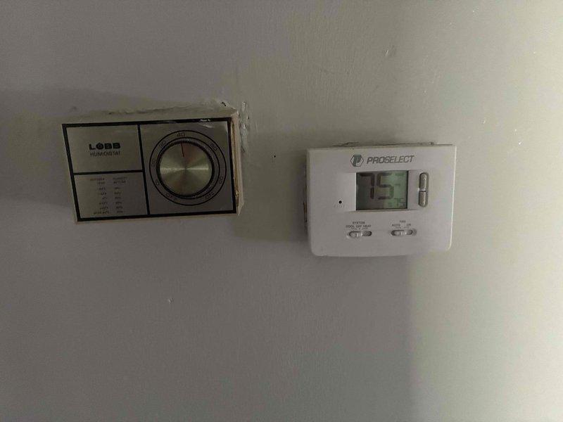 Completed on-site assessment for air conditioning system and tankless water heater replacement. Evaluated existing HVAC controls including older Lobb humidistat and ProSelect programmable thermostat, and inspected current Richmond Integra 6-year tank-style water heater with copper supply piping in utility closet adjacent to laundry appliances. Documented equipment specifications and installation conditions, provided estimate for requested system upgrades.