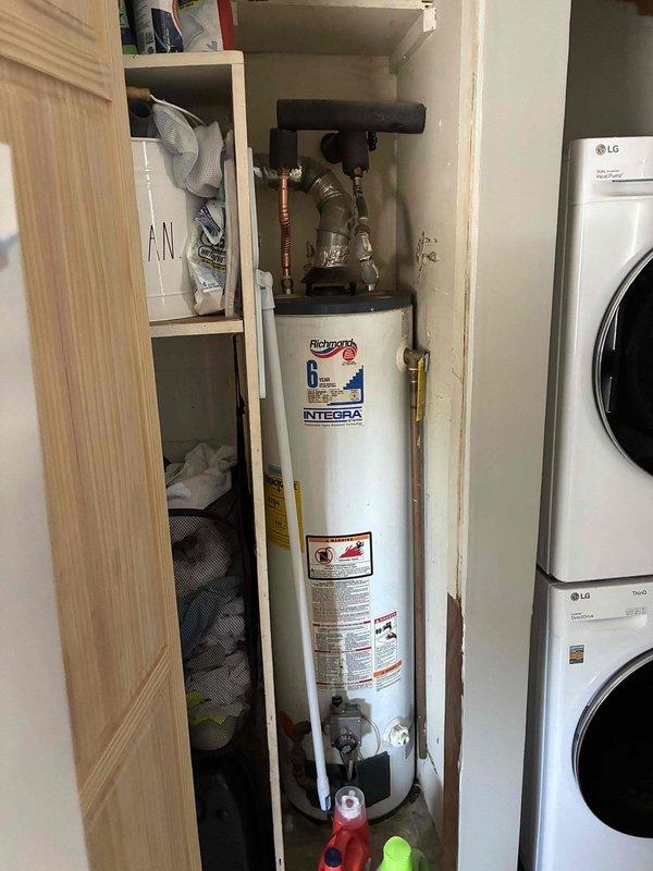 Completed on-site assessment for air conditioning system and tankless water heater replacement. Evaluated existing HVAC controls including older Lobb humidistat and ProSelect programmable thermostat, and inspected current Richmond Integra 6-year tank-style water heater with copper supply piping in utility closet adjacent to laundry appliances. Documented equipment specifications and installation conditions, provided estimate for requested system upgrades.
