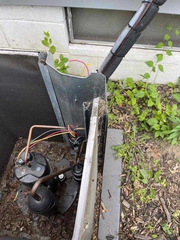 Completed scheduled maintenance agreement visit for AC system. Upon arrival, found outdoor condensing unit heavily overgrown with vegetation, including vines and plants growing through internal components. Unit housing showed significant dirt accumulation and weathering. Internal inspection revealed debris, leaves, and organic matter throughout mechanical compartment affecting compressor, copper refrigerant lines, and electrical connections. Cleared all vegetation from unit interior and exterior, removed accumulated debris, and cleaned condensing coil. Inspected all electrical connections and refrigerant line connections for integrity. Verified proper compressor operation and system functionality following cleaning. Documented pre- and post-service conditions with photographs. Recommended more frequent vegetation control around unit location to prevent future growth interference with equipment operation and maintain proper airflow clearance.