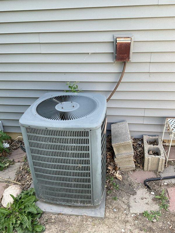 Completed comprehensive estimate for replacement of existing residential HVAC system including outdoor air conditioning condenser unit and indoor furnace installation. Assessed current equipment condition, noting vegetation growth on condenser unit, weathered refrigerant lines with patina buildup, and aging disconnect box with rust accumulation. Evaluated indoor furnace system with existing ductwork configuration and provided recommendations for complete system replacement to improve efficiency and reliability.