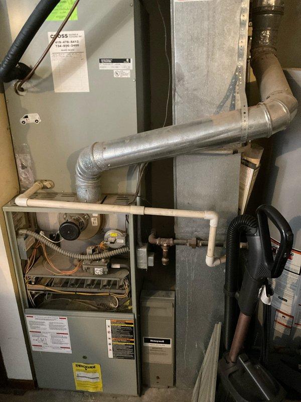 Completed comprehensive HVAC system estimate for replacement of existing Trane XE 80 furnace installation in residential basement utility room. Documented current system configuration including furnace unit, metal ductwork, PVC condensate drainage piping, electrical control panels, and associated ventilation components for replacement quote preparation.