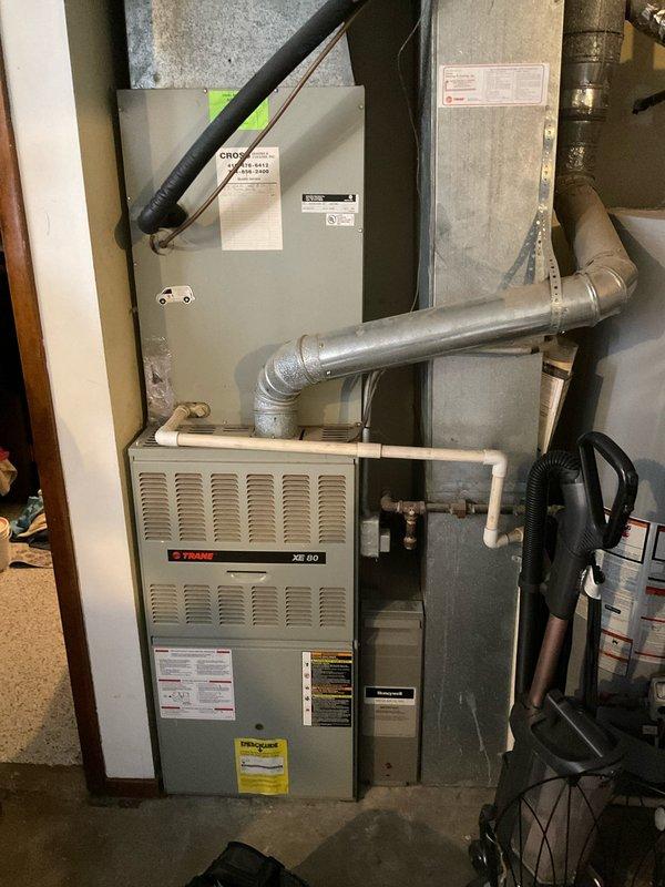 Completed comprehensive HVAC system estimate for replacement of existing Trane XE 80 furnace installation in residential basement utility room. Documented current system configuration including furnace unit, metal ductwork, PVC condensate drainage piping, electrical control panels, and associated ventilation components for replacement quote preparation.