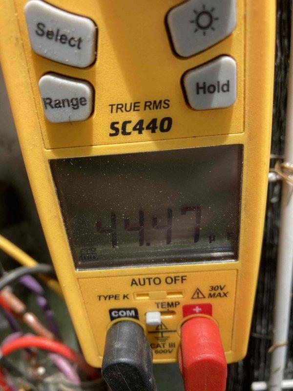 Completed AC CLUB 12-4 preventive maintenance agreement visit. Performed system diagnostics using Fluke TRUE RMS multimeter, recording voltage reading of 344.7V at the condensing unit. Inspected outdoor condenser coil and found heavy accumulation of dirt, debris, and organic matter throughout the fin structure with significant discoloration present. Noted debris collection at base of unit including leaves and twigs requiring attention for optimal airflow and system efficiency.