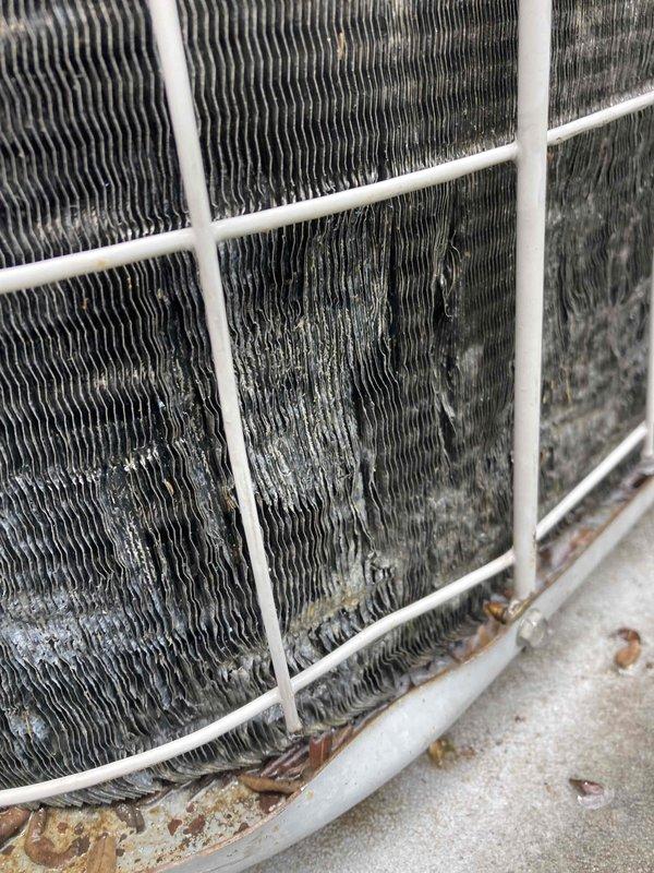 Completed AC CLUB 12-4 preventive maintenance agreement visit. Performed system diagnostics using Fluke TRUE RMS multimeter, recording voltage reading of 344.7V at the condensing unit. Inspected outdoor condenser coil and found heavy accumulation of dirt, debris, and organic matter throughout the fin structure with significant discoloration present. Noted debris collection at base of unit including leaves and twigs requiring attention for optimal airflow and system efficiency.