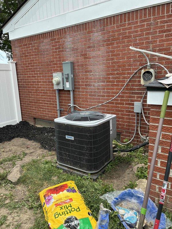 Conducted comprehensive HVAC system evaluation for replacement estimate, assessing both existing indoor air handler unit located in basement utility area and outdoor condenser unit positioned at exterior brick wall. Documented current system configuration including ductwork connections, electrical conduit routing, PVC condensate drainage piping with proper securing, and exterior electrical service connections. Provided detailed quote options for single component replacement and complete system replacement to address equipment replacement needs.