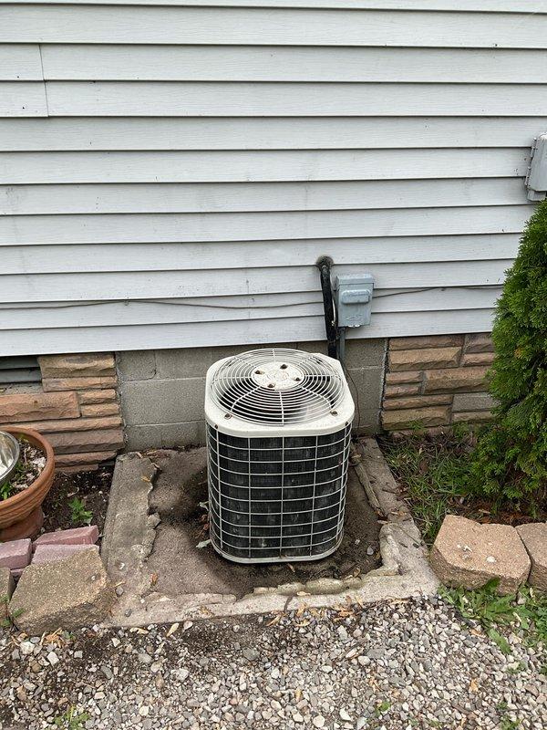 Conducted comprehensive HVAC system evaluation for replacement estimate, documenting existing equipment including indoor furnace unit with connected ductwork and copper refrigerant lines in basement utility area, and outdoor condensing unit with protective wire mesh cage positioned on concrete pad against exterior wall. Photographed current system components, installation configuration, and equipment conditions to develop accurate replacement specifications for complete air conditioning system upgrade.