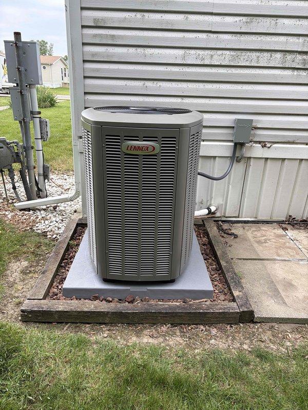 Completed full HVAC system installation including a 60,000 BTU furnace and 3-ton Lennox air conditioning unit at rear of residence. The outdoor condenser was positioned on a concrete pad with proper electrical disconnect, conduit connections, and gas line hookup utilizing flexible yellow corrugated tubing. All electrical wiring, gas valve connections, PVC venting, and system controls were installed and reconnected per manufacturer specifications, with the system tested and operational upon completion.