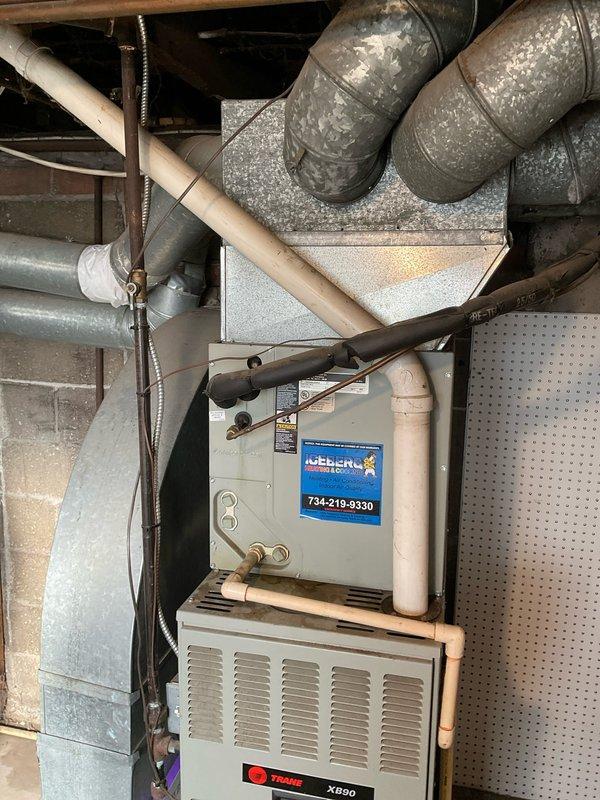 Conducted on-site assessment for HVAC system replacement in upper apartment unit. Documented existing Trane XB90 furnace installation with air handler, including electrical panel configuration, ductwork layout, condensate drainage system, and utility connections in basement mechanical space. Photographed current equipment condition and surrounding infrastructure to provide comprehensive estimate for replacement system.