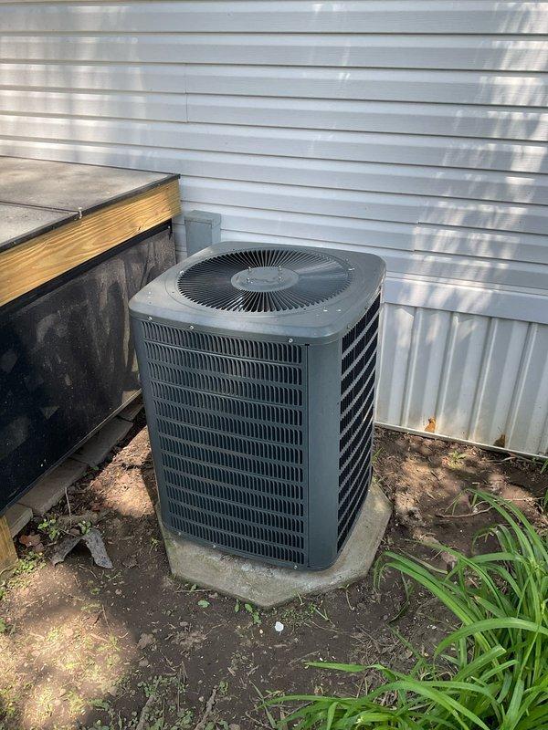 Completed on-site evaluation for HVAC system replacement estimate. Inspected existing outdoor condensing unit and indoor air handler installation, documented current equipment condition and placement. Photographed exterior condenser unit positioned on concrete pad against building with electrical disconnect, and interior air handler location in hallway area. Assessed accessibility for potential equipment replacement, reviewed installation space constraints, and gathered necessary measurements and specifications to prepare comprehensive system replacement quote.
