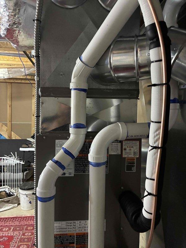 Completed full HVAC system installation including a 70,000 BTU gas furnace and 3-ton air conditioning unit in rear utility room configuration. Installation included mechanical and electrical connections, humidifier integration, refrigerant line set with proper insulation, PVC condensate drain lines, and reconnection of all system components. All equipment labeled, secured, and tested for proper operation per manufacturer specifications.