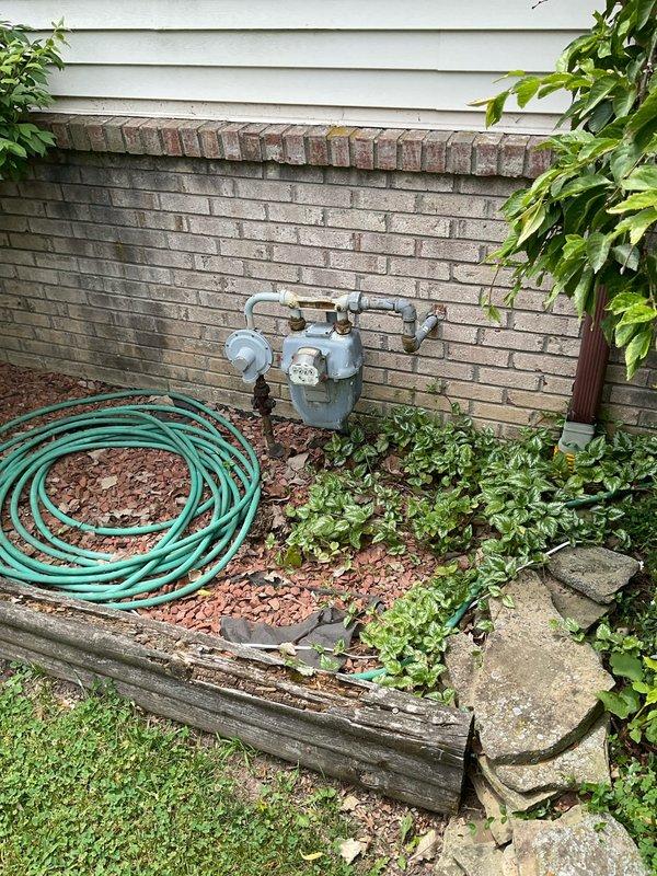 Conducted on-site evaluation for air conditioning replacement at residential property. Assessed existing HVAC system including basement-mounted furnace with connected ductwork and piping infrastructure. Inspected exterior utility connections and meter location to determine compatibility requirements for new AC unit installation. Documented current equipment configuration, ductwork routing through exposed ceiling joists, and available space for condensing unit placement in landscaped area adjacent to brick foundation. Photographed existing system components and exterior installation site to develop accurate replacement estimate and equipment specifications.