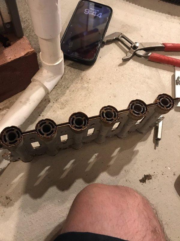 Performed comprehensive tune-up and inspection on furnace and air conditioning system. Upon inspection, discovered severely corroded gas manifold assembly with significant rust deterioration affecting multiple ports and connecting components, which poses potential safety and operational concerns. Documented equipment condition with photographic evidence for service records and future reference.