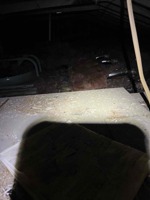 Responded to no cooling complaint on air conditioning system. Upon inspection, found severely corroded outdoor unit cabinet panel with extensive rust damage compromising structural integrity and potentially affecting unit performance. Observed significant deterioration on metal surfaces indicating prolonged moisture exposure and weathering. Inspected attic space and indoor components, noting insulation condition and ductwork connections. Documented equipment condition with photographs showing corroded outdoor unit panel and attic area for service records and recommended repairs.