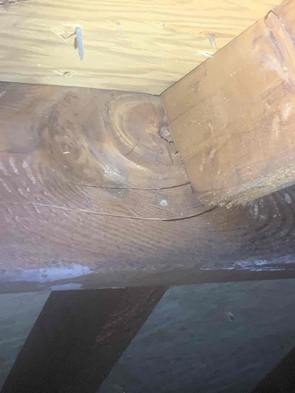 Responded to callback regarding subcontractor's concern about potentially damaged roof truss during HVAC installation. Conducted thorough inspection of attic/crawlspace area and documented conditions with detailed photography of ceiling structure, wall joints, and installation area. Performed exterior inspection and verification of roofline levelness using precision measuring tools to assess structural integrity and proper alignment of gutter system and fascia components.