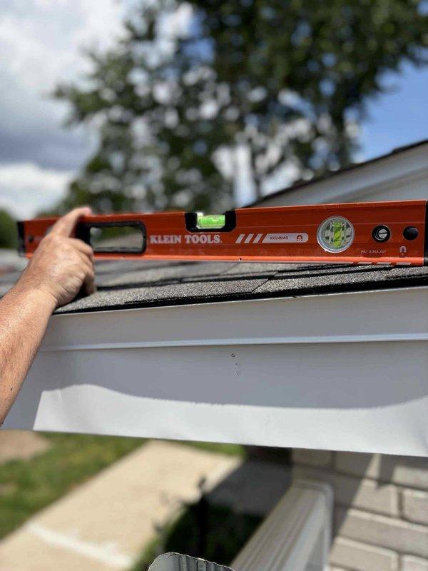 Responded to callback regarding subcontractor's concern about potentially damaged roof truss during HVAC installation. Conducted thorough inspection of attic/crawlspace area and documented conditions with detailed photography of ceiling structure, wall joints, and installation area. Performed exterior inspection and verification of roofline levelness using precision measuring tools to assess structural integrity and proper alignment of gutter system and fascia components.