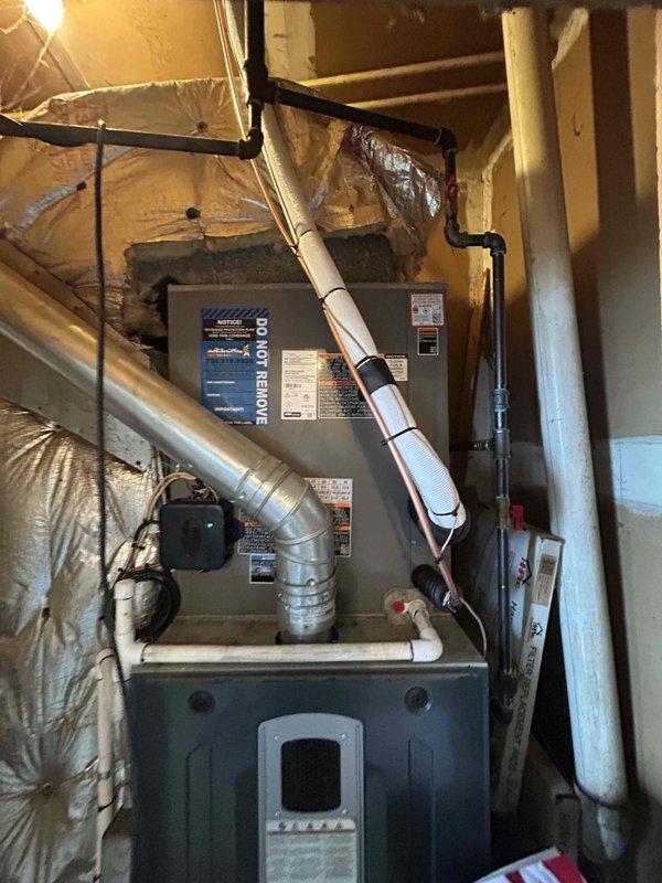Successfully installed a new 3-ton air conditioning system with matching evaporator coil on the left side of the existing furnace. Connected refrigerant lines to the outdoor condensing unit and performed complete system startup procedures. Verified proper system operation using manifold gauges, confirming refrigerant pressures of 205.0 PSI suction and 205.4 PSI discharge with ambient temperature reading of 100.1°F. All electrical connections completed to manufacturer specifications, including reconnection of thermostat wiring and power supply. System tested and running efficiently with proper airflow through ductwork.