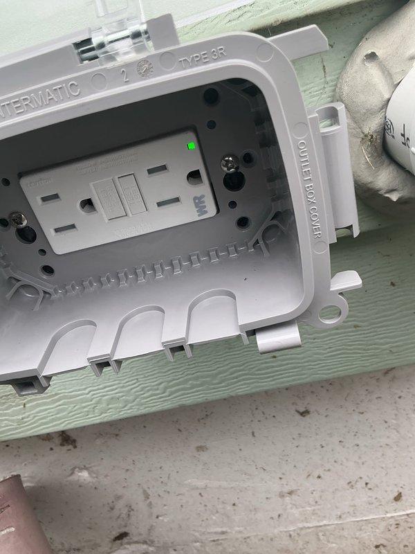Installed a weatherproof GFCI outlet in an Intermatic Type 3R rated enclosure on the building exterior. The ground fault circuit interrupter was properly wired, tested for functionality with the LED indicator confirming power, and the hinged clear protective cover was secured to maintain weather resistance per code requirements.