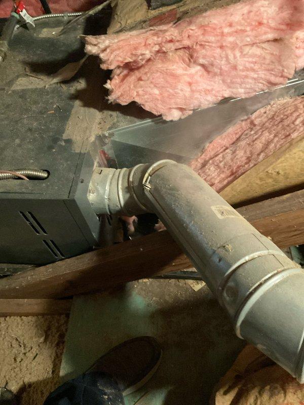 Conducted comprehensive HVAC system assessment in attic space for air conditioning replacement estimate. Evaluated existing ductwork assembly showing significant age and wear, with deteriorated fiberglass insulation exhibiting compression, discoloration, and substantial degradation requiring replacement consideration. Documented current system conditions including metal ductwork with reflective foil covering, PVC drain line connections, electrical junction box placement, and flexible conduit routing to provide accurate equipment replacement specifications and identify necessary ancillary work for complete system installation.