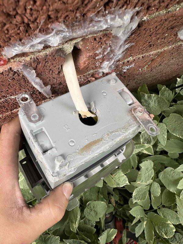 Responded to callback for exterior GFCI outlet that had pulled away from brick structure. Upon arrival, found weathered electrical box with compromised mounting and deteriorated brick material around cable entry point. Secured outlet box to wall structure, verified GFCI functionality, and confirmed weatherproof cover was properly sealed and operational.