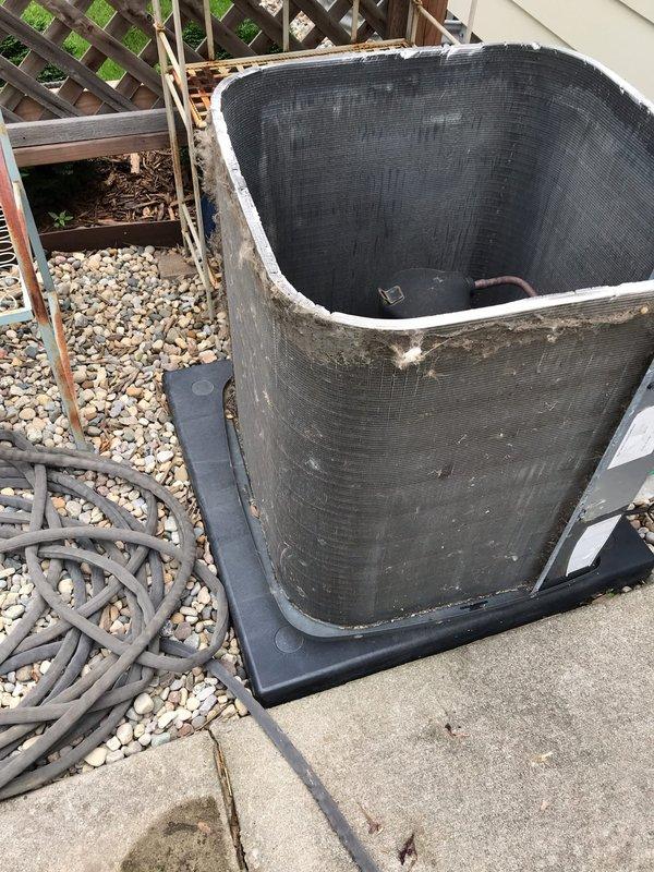 Completed preventive maintenance inspection on residential air conditioning system as part of CLUB AC 8-12 agreement. Performed comprehensive visual assessment of outdoor condensing unit, noting significant accumulation of dirt, biological growth, and organic debris around compressor and within installation area. Documented equipment condition through photographic records showing weathered exterior casing with mold and mildew buildup on surfaces, dried leaves and plant matter collected around base components, and general outdoor exposure deterioration. Inspected copper refrigerant lines, electrical connections, compressor mounting, and drain pan placement. Unit operational at time of service with all components functioning within normal parameters despite cosmetic weathering from extended outdoor exposure.