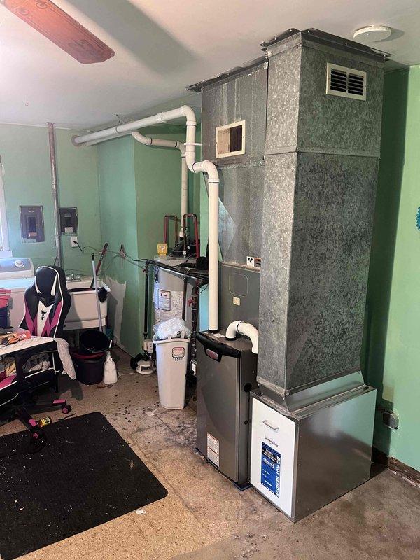 Completed installation of 70,000 BTU furnace system in residential basement utility room, including all mechanical and electrical connections. Installed new air handler unit with galvanized metal housing, connected white PVC venting system for proper exhaust and intake, and reconnected all existing ductwork to new equipment. Verified all electrical connections to code, tested system operation, and confirmed proper airflow throughout the home.