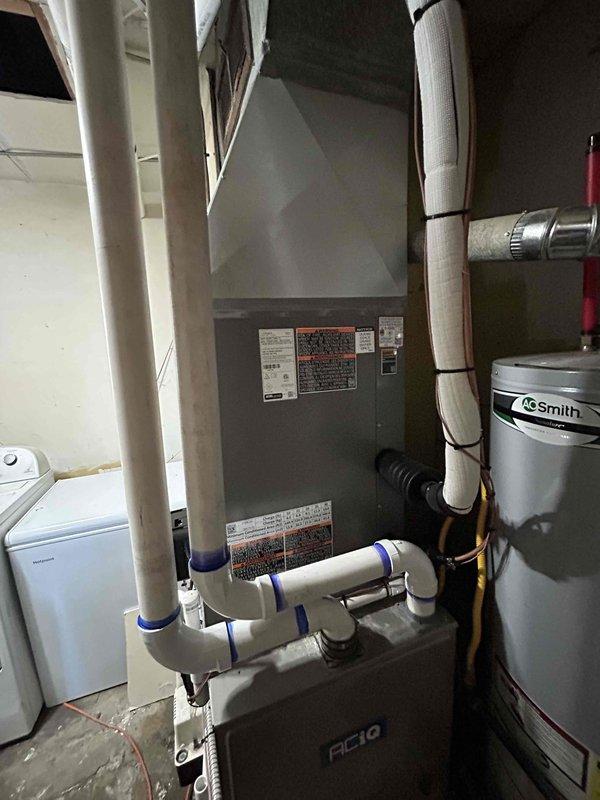 Successfully installed a new 4-ton air conditioning unit with evaporator coil in residential basement utility area. System was positioned with rear discharge configuration, all refrigerant lines were connected, condensate drainage piping was installed with proper PVC routing, and electrical connections were completed. Unit was tested for proper operation and all financing documentation was collected and processed per program requirements.