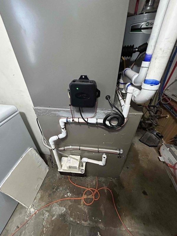 Successfully installed a new 4-ton air conditioning unit with evaporator coil in residential basement utility area. System was positioned with rear discharge configuration, all refrigerant lines were connected, condensate drainage piping was installed with proper PVC routing, and electrical connections were completed. Unit was tested for proper operation and all financing documentation was collected and processed per program requirements.