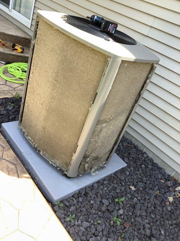 # HVAC Maintenance Visit - Ice Buildup on Outdoor Coil

Responded to service call for ice accumulation on outdoor condenser coil. Upon arrival, found AC&SI unit with significantly restricted airflow due to heavily clogged condenser coils. External coil surfaces showed substantial debris buildup consisting of dirt, dust, and organic material that was impeding proper heat transfer and causing abnormal ice formation.

Connected Fieldpiece SMAN digital manifold gauges to service ports to assess system pressures and temperatures. Initial diagnostics revealed operating conditions consistent with restricted airflow across condenser. Temperature readings displayed 306.5°F and 13.8°F at respective measurement points, indicating system imbalance.

Performed thorough cleaning of condenser coils to remove accumulated debris and restore proper airflow. Cleared both intake and discharge sides of coil assembly to ensure unrestricted air circulation. Unit was positioned on concrete pad with gravel sur