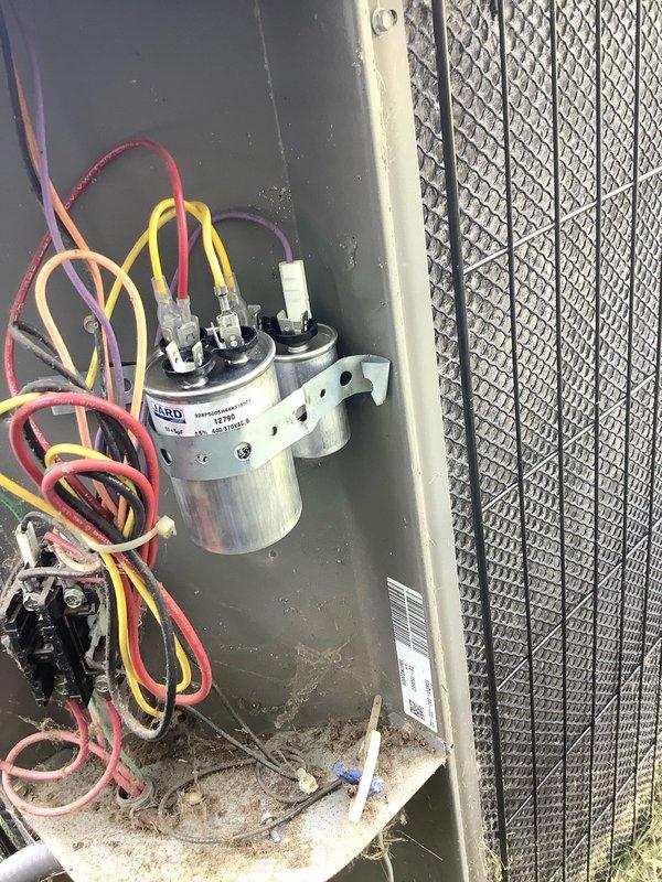 Responded to no cooling call on aging air conditioning system. Upon arrival, found unit not operating with thermostat displaying 89°F. Performed diagnostic testing and discovered failed dual run capacitor preventing compressor and condenser fan operation. Verified incoming line voltage at 120.1V to condensing unit. Removed defective capacitor from outdoor unit compartment and installed new dual run capacitor with proper microfarad ratings for both compressor and fan motor. Reconnected all electrical terminals, tested system operation, and confirmed unit cycling properly with normal amperage draw. System restored to full cooling operation.