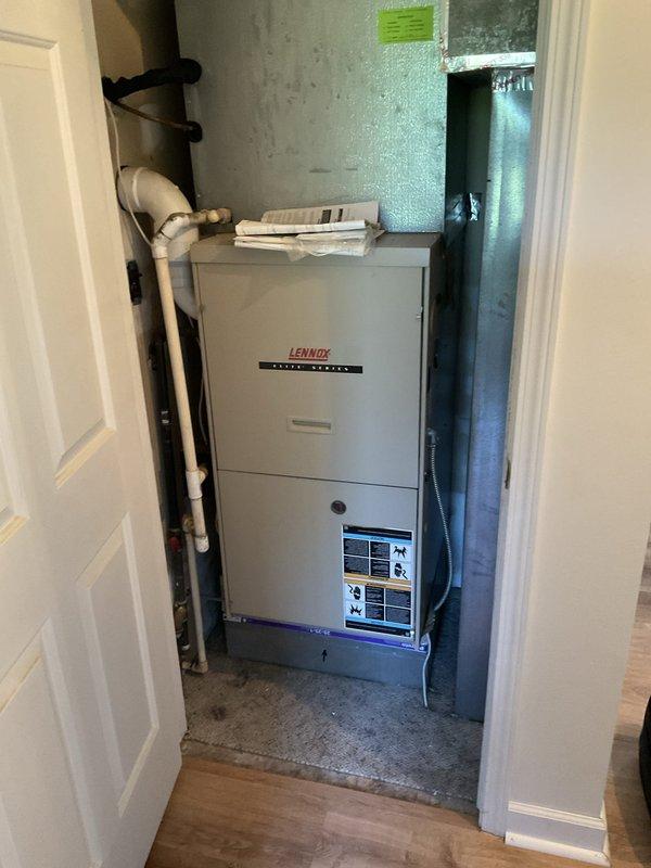 Conducted on-site evaluation of existing Lennox Pulse Series furnace installation in utility closet to prepare multiple equipment replacement estimates for new air conditioning unit. Documented current HVAC system configuration, electrical service panel location in adjacent laundry area, existing PVC venting arrangement, and ductwork connections to provide accurate specifications for AC replacement options.