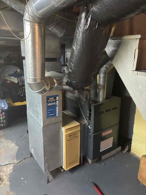 Conducted on-site evaluation of existing 15+ year old air conditioning system to provide replacement estimate. Assessed current HVAC equipment configuration in basement installation, including air handling unit and associated ductwork connections. Documented existing system layout and components through photographic records, capturing metallic air handling unit, Goodman furnace, flexible and rigid ductwork, and basement infrastructure. Discussed replacement options and financing terms for new air conditioning system to address aging equipment concerns.