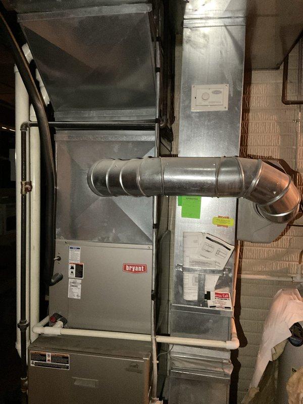 Conducted on-site evaluation of existing residential HVAC system for replacement estimate. Assessed 18-20 year old air conditioning unit and associated Bryant furnace system with air handler in basement utility area. Documented current equipment configuration, ductwork connections, condensate drainage system, and overall installation condition through photographic documentation to provide comprehensive replacement options for aging cooling system.