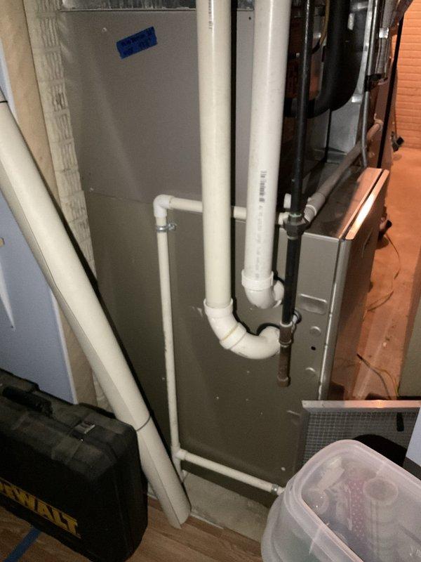 Conducted on-site evaluation of existing residential HVAC system for replacement estimate. Assessed 18-20 year old air conditioning unit and associated Bryant furnace system with air handler in basement utility area. Documented current equipment configuration, ductwork connections, condensate drainage system, and overall installation condition through photographic documentation to provide comprehensive replacement options for aging cooling system.