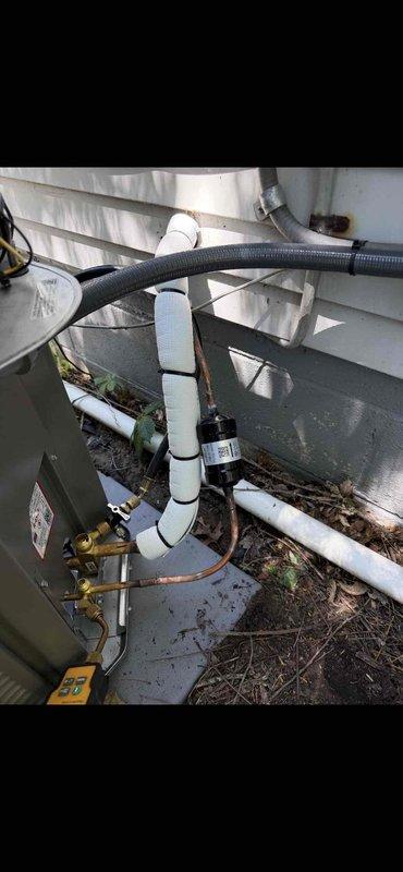 Successfully completed installation of a 2-ton air conditioning system with matching evaporator coil in rear location. Installed outdoor condensing unit on concrete pad with proper refrigerant line connections, electrical disconnect box with weather-resistant components, and PVC condensate drainage system. All copper refrigerant lines were properly insulated with foam wrapping, electrical connections were secured with appropriate conduit, and brass valve fittings were installed for system serviceability. Unit was fully reconnected, tested for proper operation, and system commissioned per manufacturer specifications.