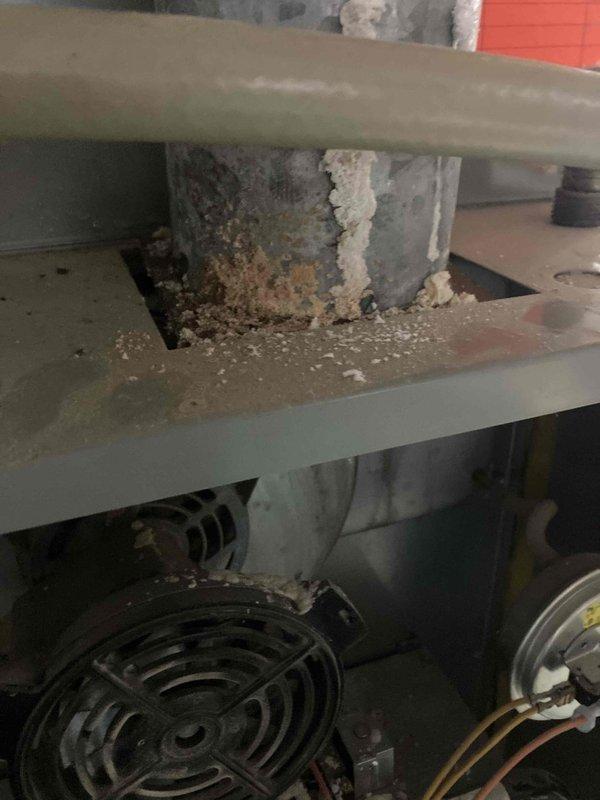 Responded to no cooling complaint on aging unit. Performed diagnostic assessment revealing significant temperature differential issues, with supply air measuring 8.2°C indicating compromised system performance. Upon inspection, discovered extensive corrosion and deterioration throughout interior components, including heavy rust on structural supports and evidence of long-term moisture exposure affecting critical mechanical assemblies.
