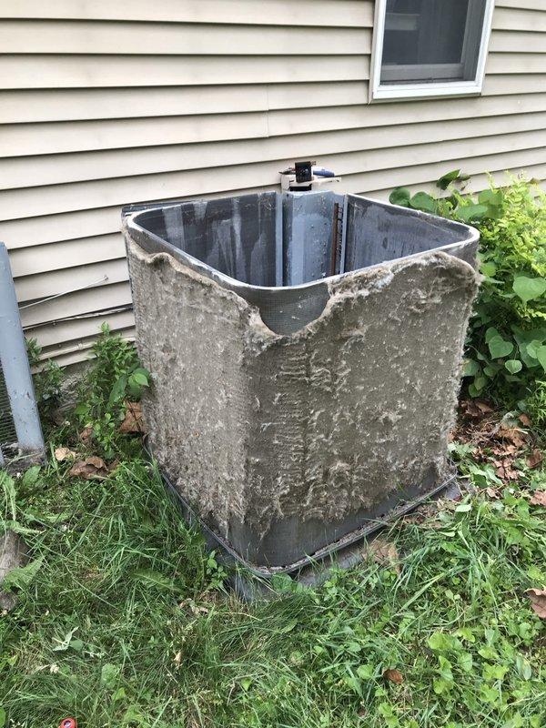 # HVAC Service Completed

Responded to a no-cooling complaint on a 2-year-old residential air conditioning system. Upon arrival, found the outdoor condenser unit heavily covered with dirt, grime, mold, and organic growth, with surrounding vegetation encroaching on the equipment. The unit's exterior surfaces showed extensive contamination that was restricting proper airflow through the condenser coil.

Performed comprehensive cleaning of the condenser unit, removing accumulated debris, organic matter, and biological growth from all exterior surfaces and coil fins. Cleared vegetation and debris from around the unit perimeter to restore proper clearance for adequate airflow. Inspected internal components and found copper refrigerant lines intact with no visible damage. Noted significant weathering and rust accumulation on the base pan and mounting surfaces, though structural integrity remained sound.

After cleaning, verified system operation with normal airflow through the condenser coil