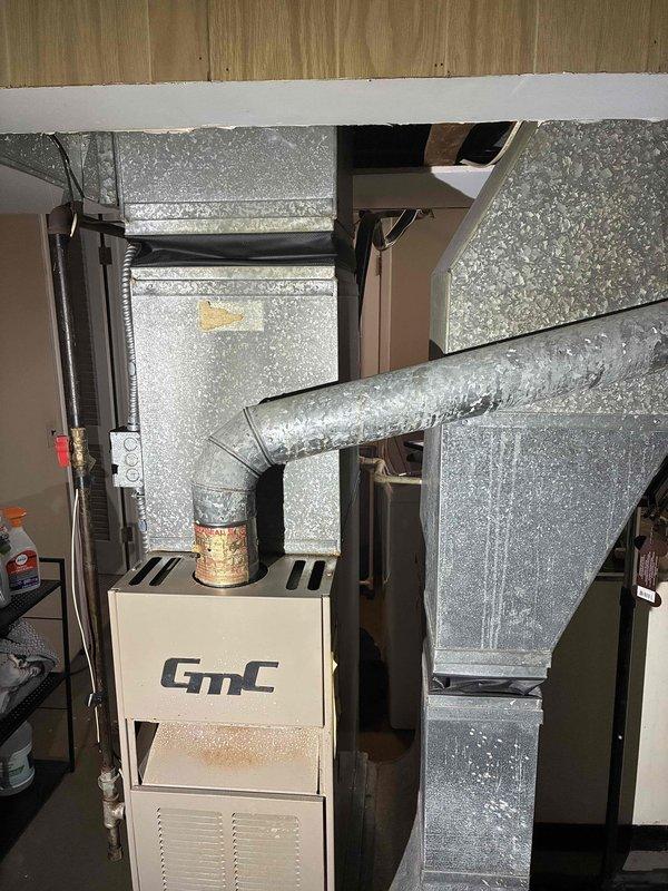 Provided estimate for complete HVAC system replacement including both air conditioning unit and natural gas furnace located in basement. Current 10+ year old system experiencing intermittent fan shutdown on AC condenser unit. Assessed existing GMC furnace showing rust staining on lower panel and outdoor condenser unit mounted on concrete pad at rear exterior. Quoted replacement of both heating and cooling components to address equipment age and current operational issues with AC fan cycling.