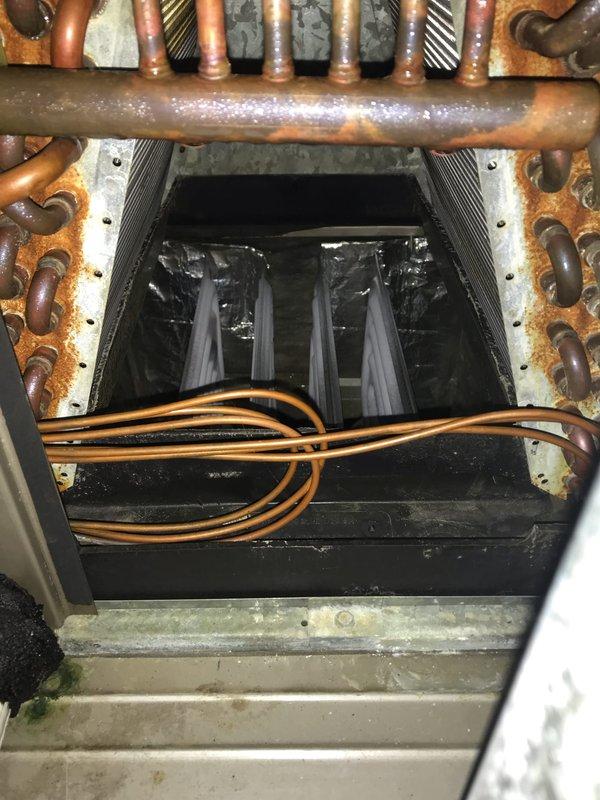 Responded to no-cool service call and found air conditioning system operational but condensate pump actively leaking. Upon inspection, determined pump to be original equipment, estimated over 10 years old, showing significant wear and deterioration. Documented motor housing condition with visible dust accumulation and operational wear patterns, as well as heat exchanger assembly displaying moisture accumulation, copper tubing configuration, and corrosion on metal framework consistent with age and extended service life. System currently maintaining cooling functionality despite pump leak, but replacement recommended due to age and active failure to prevent water damage and potential system shutdown.