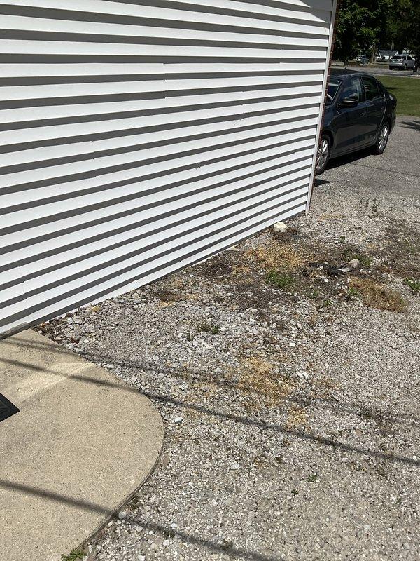 Conducted on-site assessment for single zone mini split air conditioning system installation in office space. Evaluated exterior wall conditions, existing utility locations including gas meter placement, and potential mounting locations for outdoor condenser unit. Documented gravel pad area and building exterior with horizontal siding for equipment placement considerations. Assessed electrical requirements and condensate drainage options to provide comprehensive installation estimate.