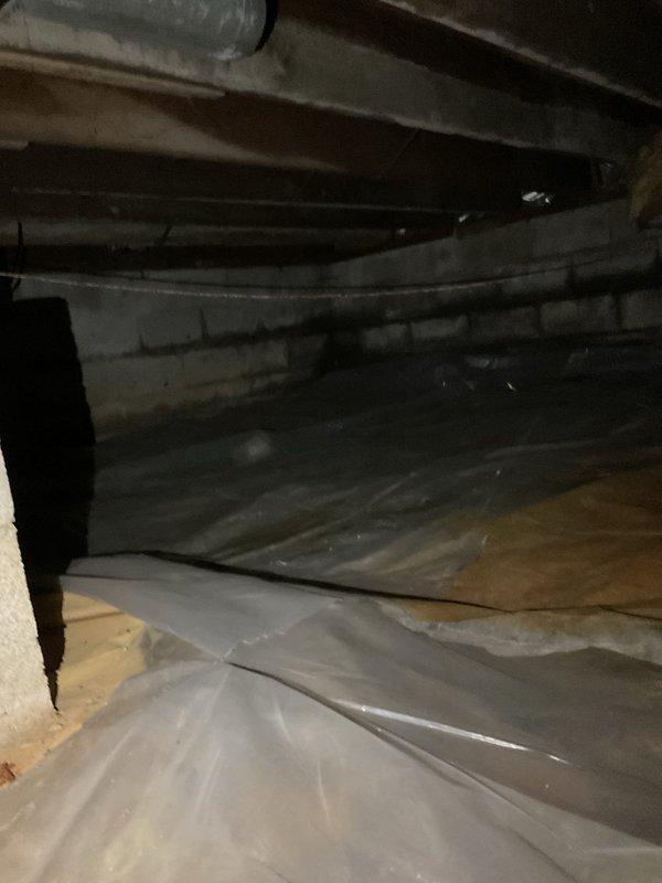 Conducted site assessment of crawl space to evaluate ductwork requirements for large room experiencing insufficient airflow. Inspected existing HVAC infrastructure including exposed joists, vapor barrier condition, and available routing paths for new duct installation. Documented crawl space dimensions, clearance heights, and structural obstacles including PVC plumbing lines and concrete block foundation walls. Evaluated optimal duct run placement to maximize air delivery while minimizing installation complexity in confined space with limited access. Provided estimate for materials and labor required to install properly sized supply duct from main trunk line to address inadequate air circulation in affected room.